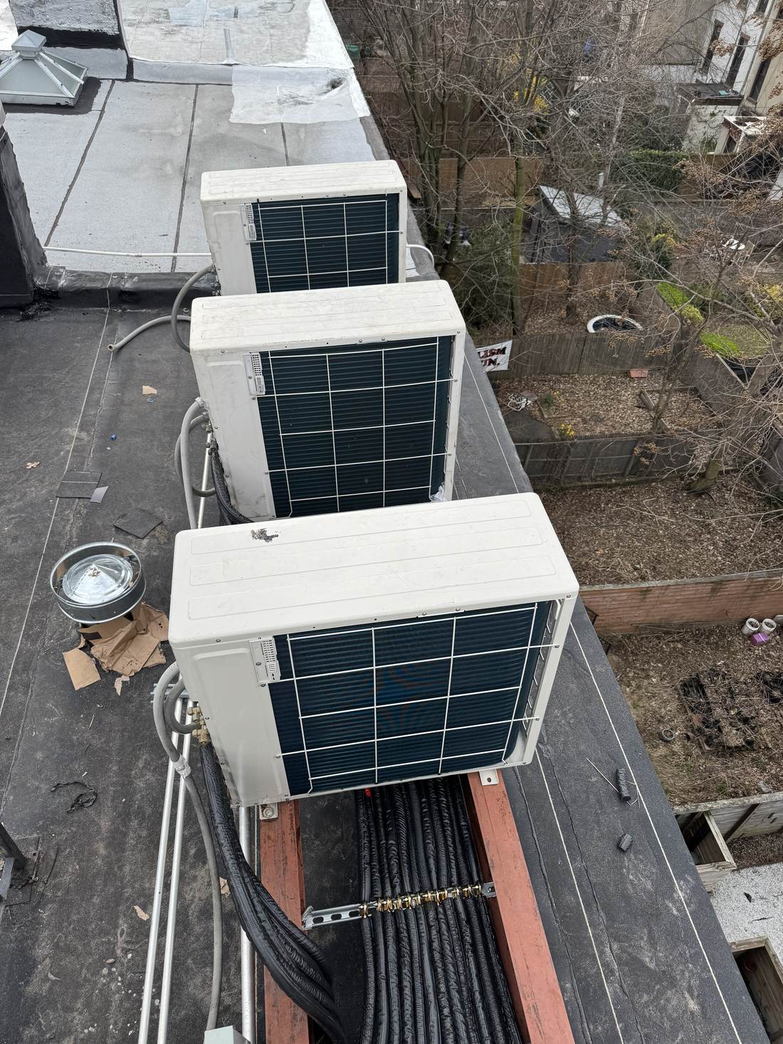 Three rooftop condenser units serving a multi-zone Brooklyn heat pump installation